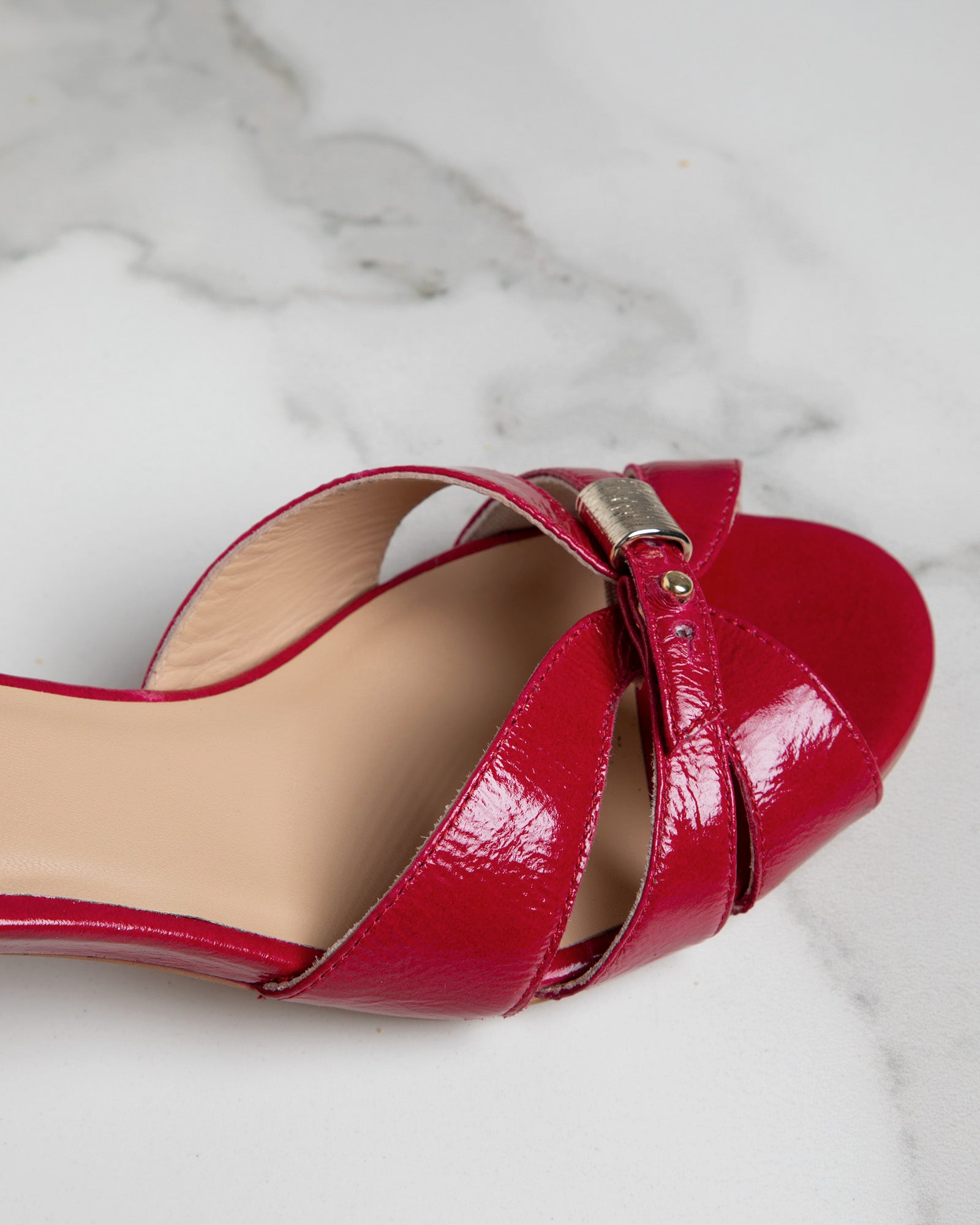 Gros plan de la sandale Alba en cuir verni fuchsia montrant le système de réglage à l’avant-pied et l’espace prévu pour accompagner les différentes morphologies de pieds.